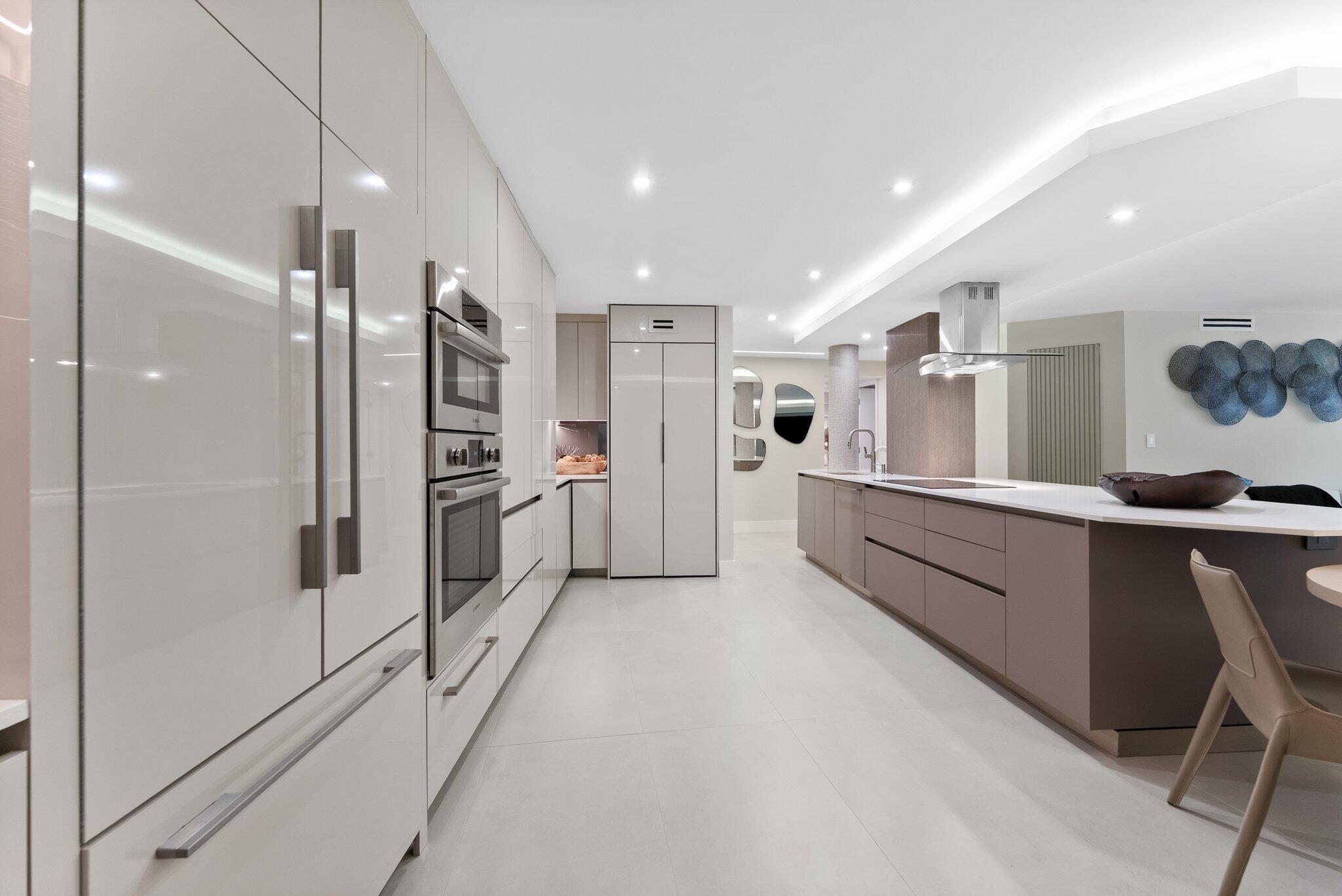 875 East Camino Real, Unit 2G Boca Raton, FL 33432 - Photo 9 of 55 a large white kitchen with a refrigerator and a sink