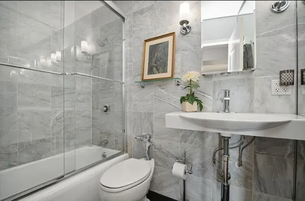 a bathroom with a sink toilet a mirror and shower