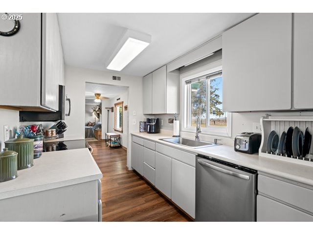 33968 East Loop Road Stanfield, OR 97875 - Photo 9 of 48 a kitchen with counter top space a sink wooden floor and cabinets