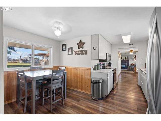 33968 East Loop Road Stanfield, OR 97875 - Photo 10 of 48 a kitchen with stainless steel appliances granite countertop a refrigerator a stove a sink a dining table and chairs with wooden floor