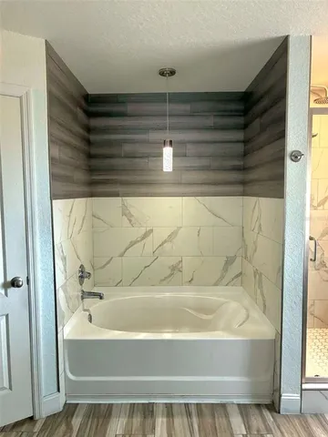 a bathroom with a tub and shower
