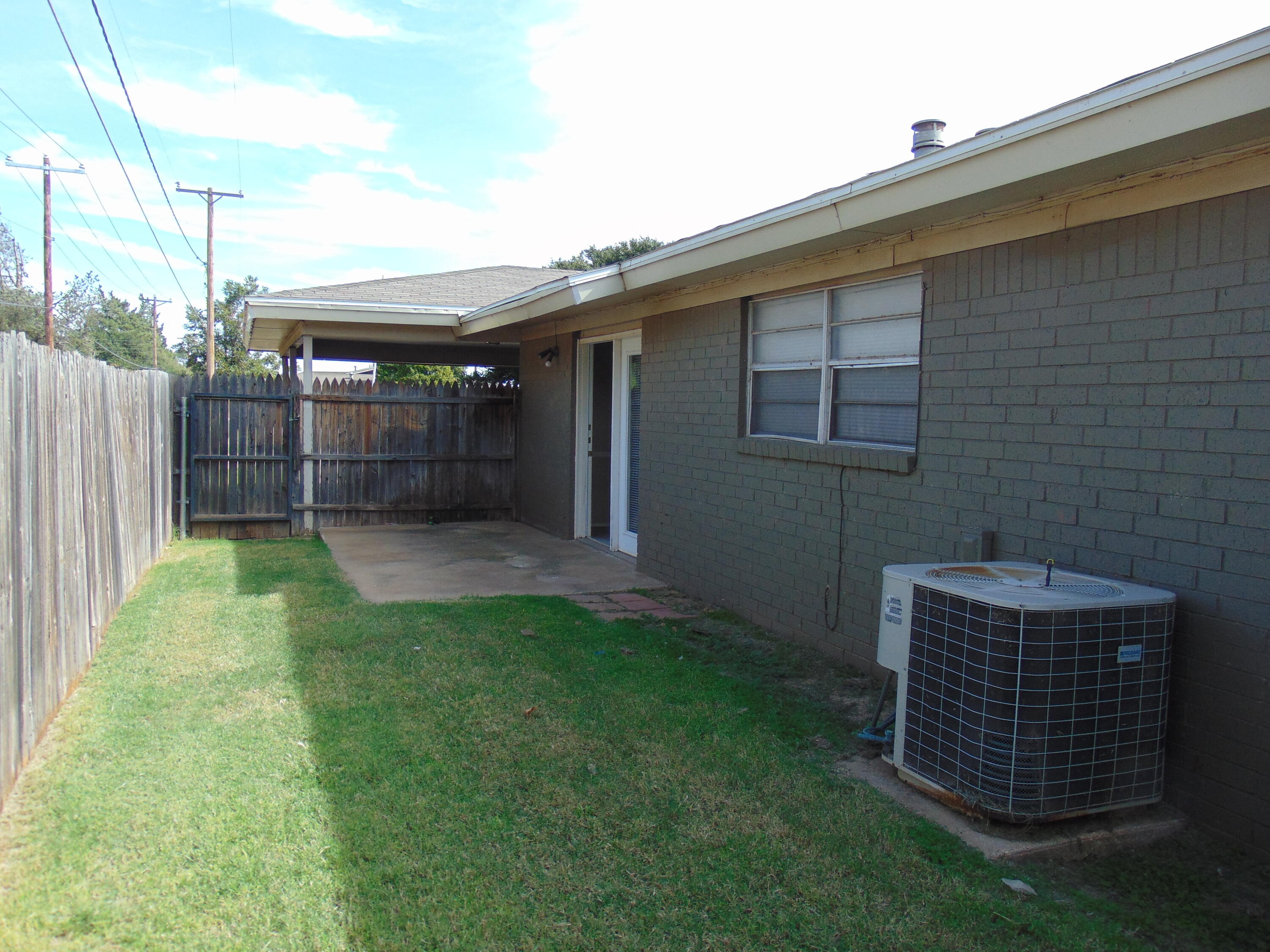 6910 Fremont Avenue, Unit A Lubbock, TX 79413 - Photo 2 of 2 a backyard of a house with plants and wooden fence