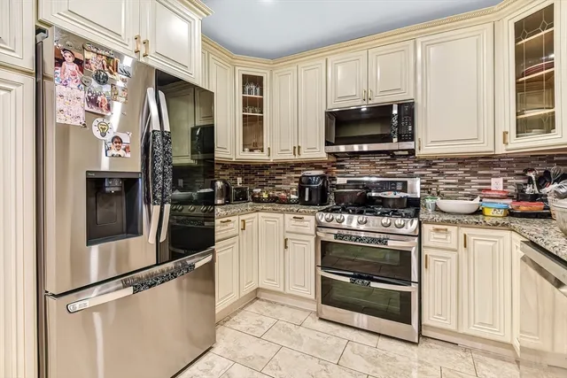 a kitchen with stainless steel appliances granite countertop a stove a sink and a microwave