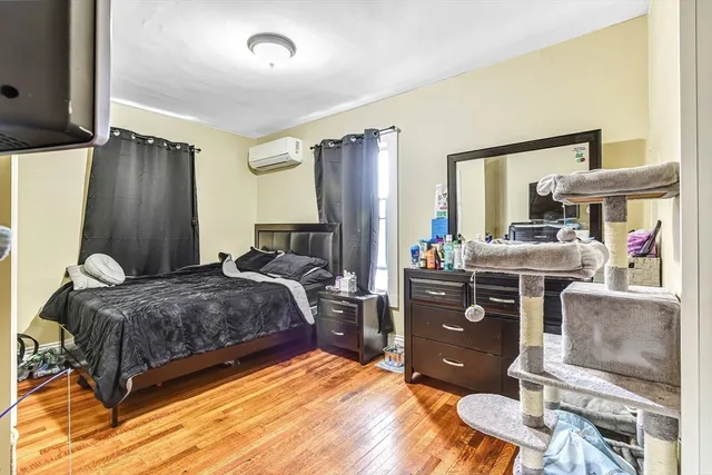 a bedroom with a bed and wooden floor