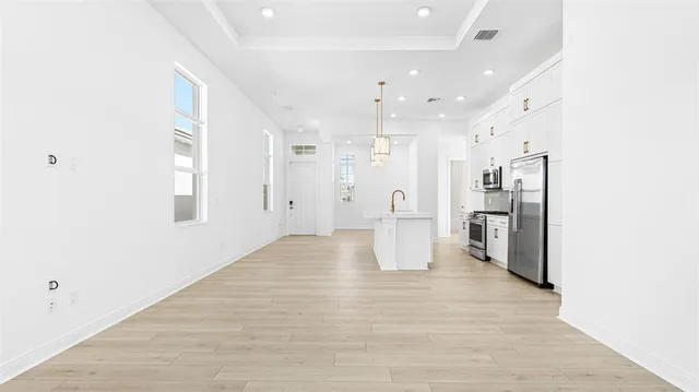 a view of a kitchen with a refrigerator and a sink
