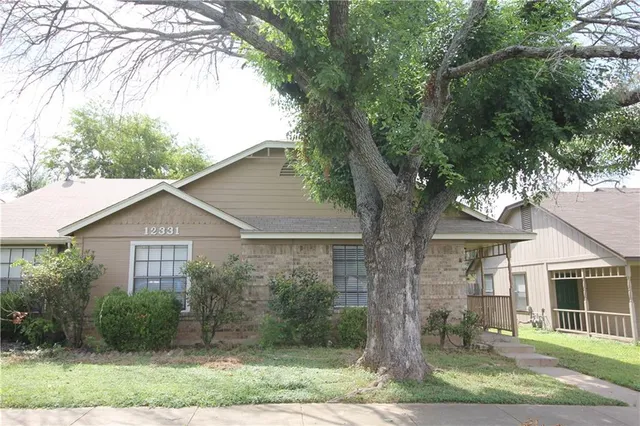 a view of a yard in front of a house with large windows