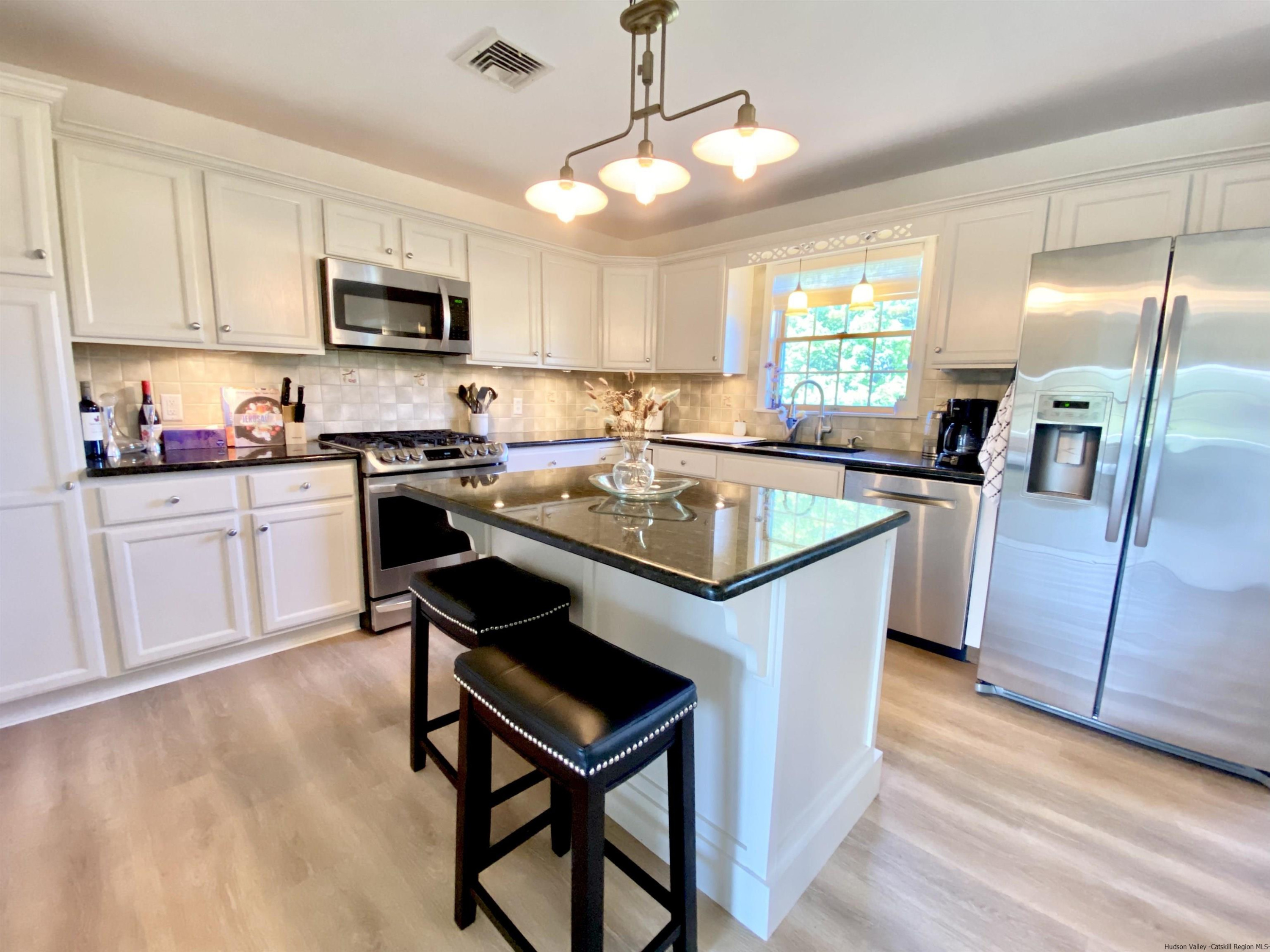 29 Millbrook Road Gardiner, NY 12589 - Photo 10 of 34 a kitchen with stainless steel appliances granite countertop a stove a sink dishwasher a microwave oven with cabinets and wooden floor