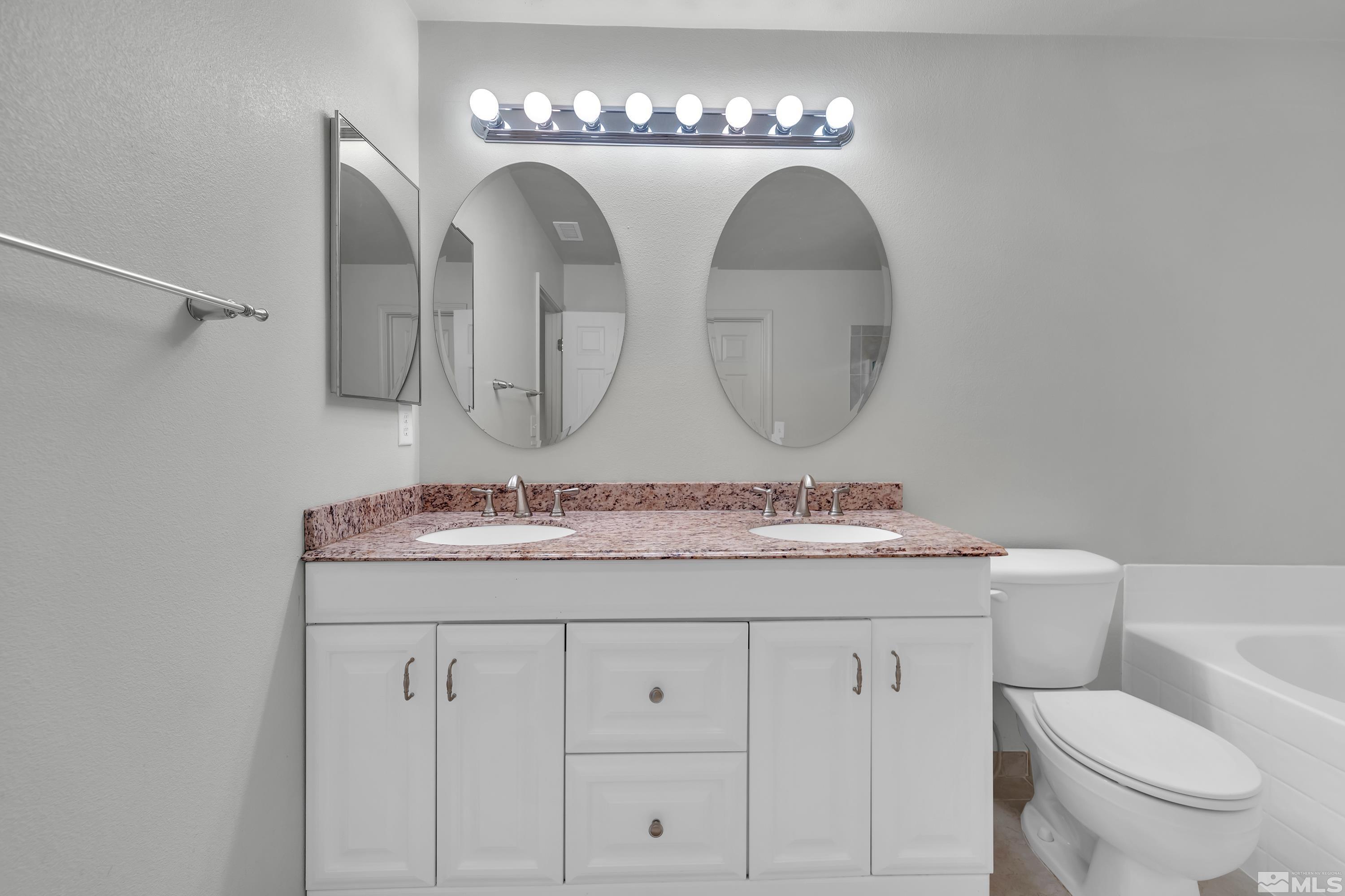 2928 Bryan Street Reno, NV 89503 - Photo 21 of 37 a bathroom with a granite countertop toilet sink and mirror