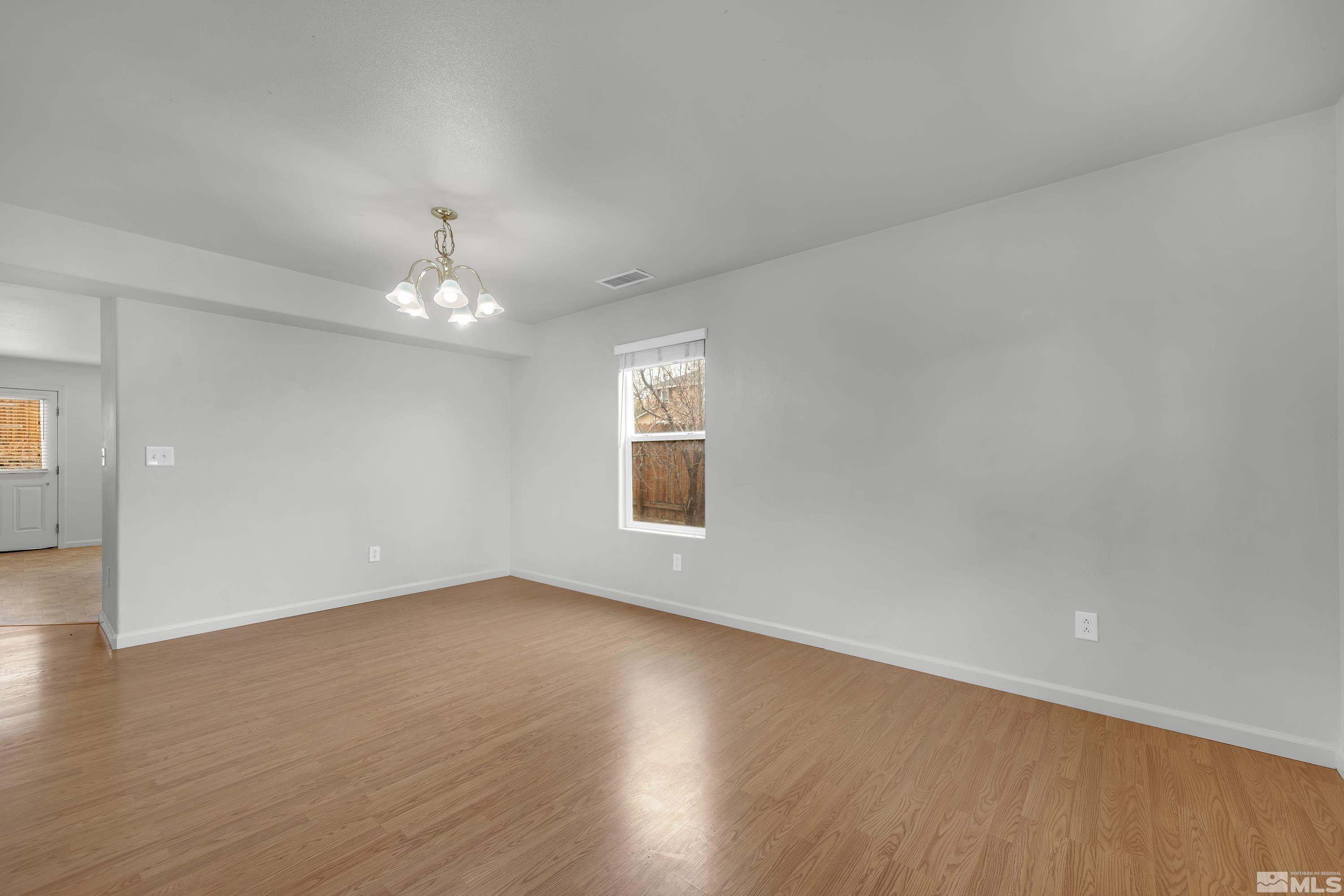 2928 Bryan Street Reno, NV 89503 - Photo 6 of 37 an empty room with wooden floor chandelier and windows