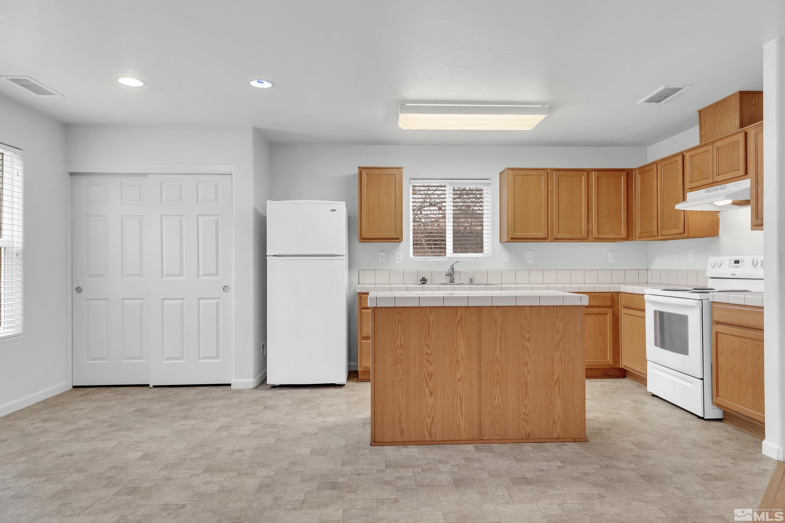 2928 Bryan Street Reno, NV 89503 - Photo 8 of 37 a kitchen with stainless steel appliances granite countertop a stove a sink and a refrigerator with wooden cabinets