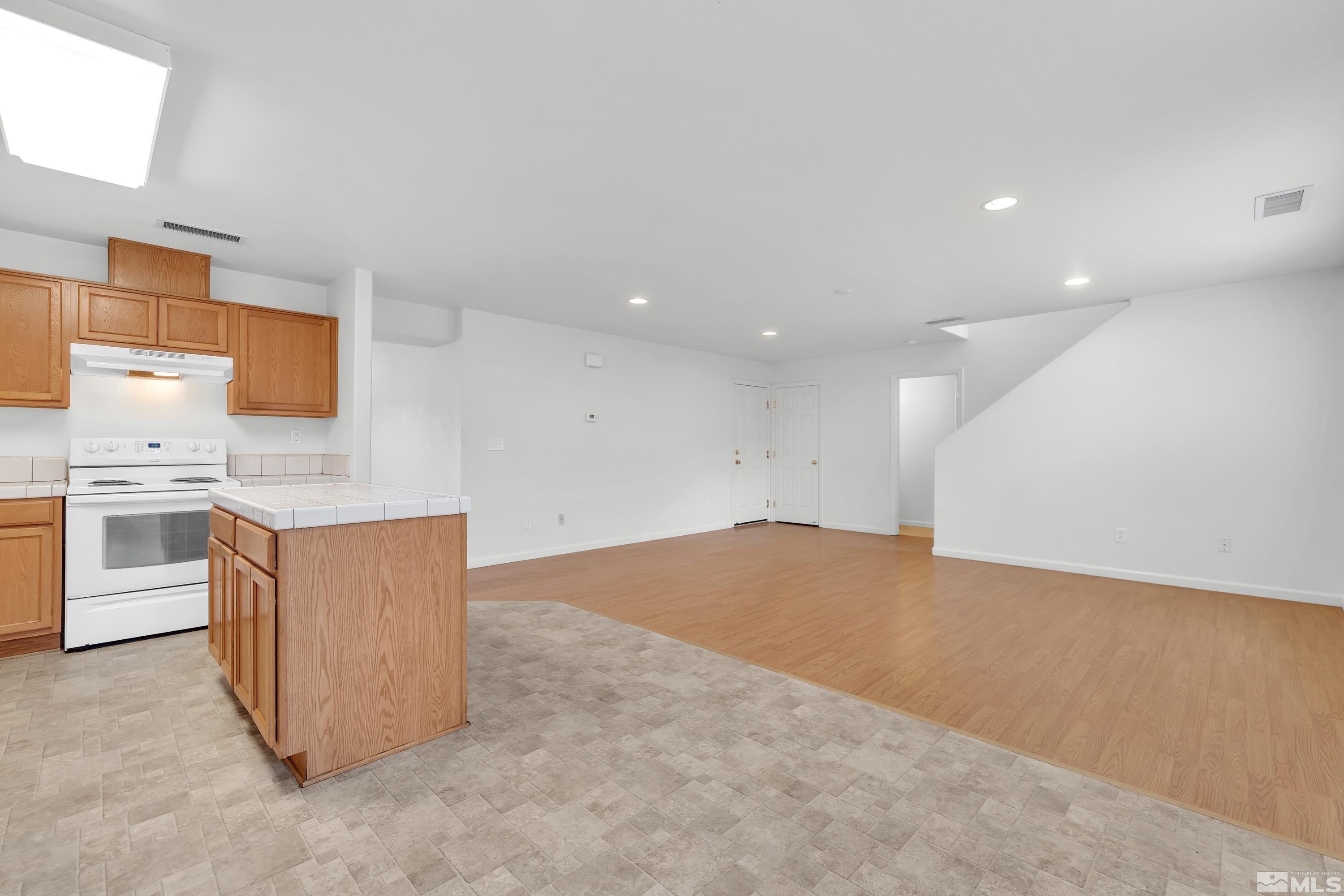 2928 Bryan Street Reno, NV 89503 - Photo 9 of 37 a kitchen with stainless steel appliances granite countertop a stove top oven a sink dishwasher and a refrigerator with wooden floor