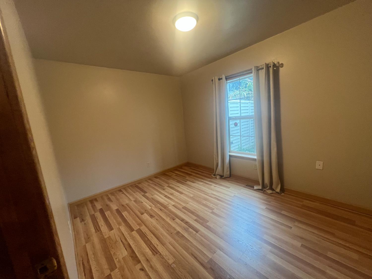 312 South Church Street Ione, CA 95640 - Photo 13 of 22 an empty room with wooden floor and windows