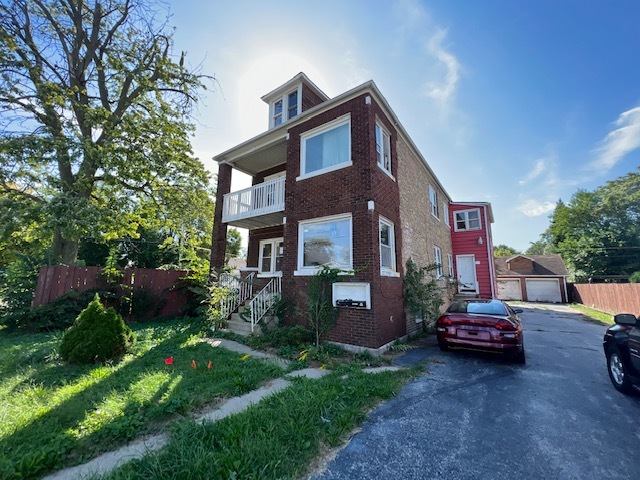 305 153rd Street Calumet City, IL 60409 - Photo 2 of 40 a front view of a house with a garden