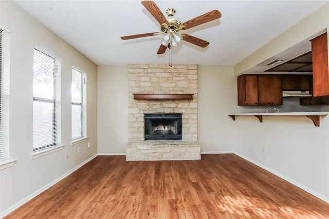 a view of an empty room with window and fire place