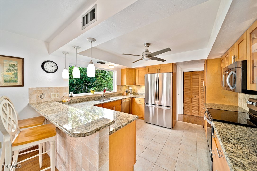 4546 Buck Key Road Sanibel, FL 33957 - Photo 12 of 41 a kitchen with stainless steel appliances granite countertop a sink and a refrigerator