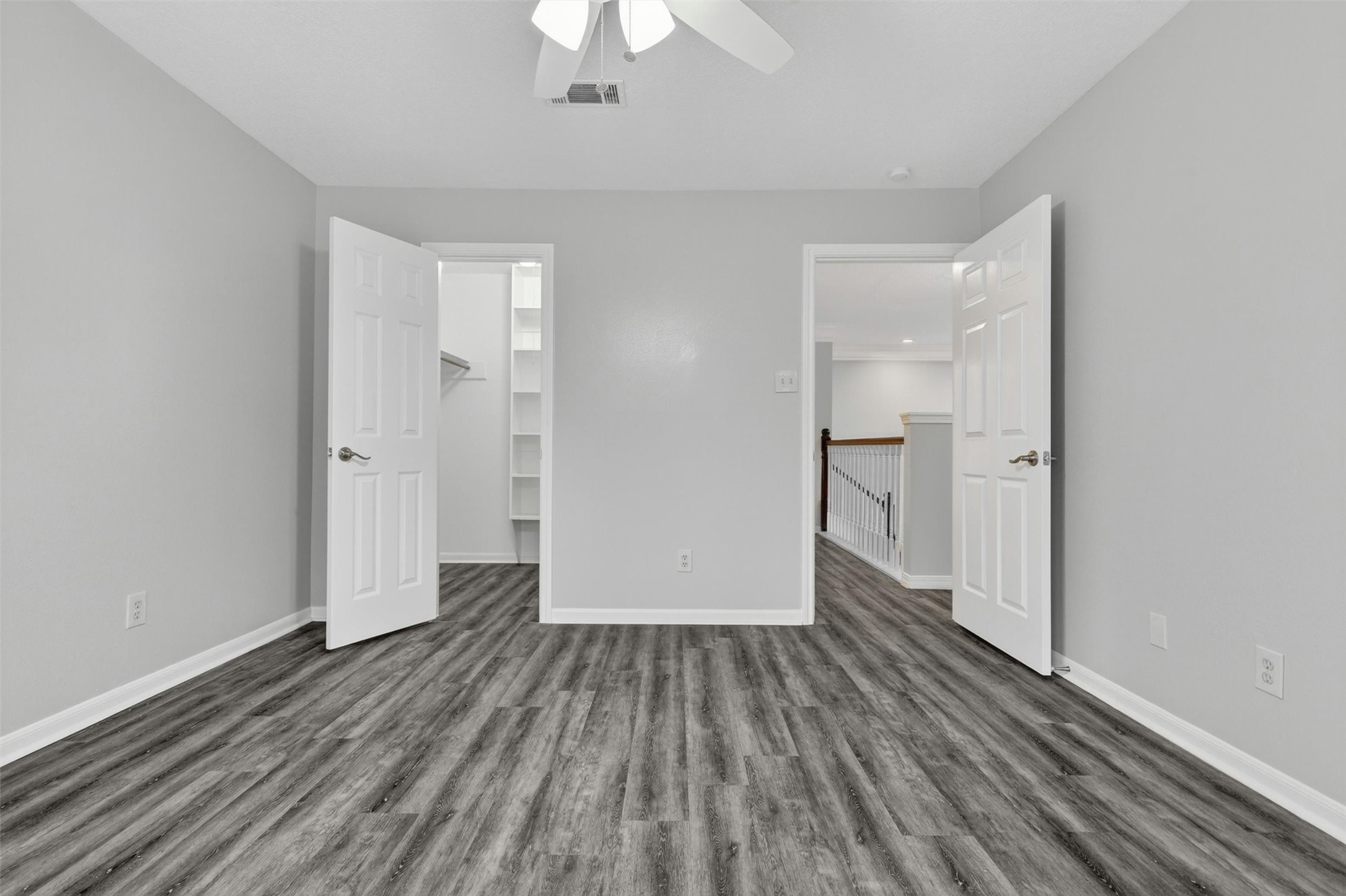 12929 Kingsbridge Lane Houston, TX 77077 - Photo 31 of 42 Spacious third bedroom featuring modern flooring, neutral designer colors, and a highly desirable walk-in closet with custom built-in shelving for added organization and storage. Buyers will love the flexible layout, bright open feel, and move-in ready condition that makes this room perfect for family, guests, a home office, or workout space.