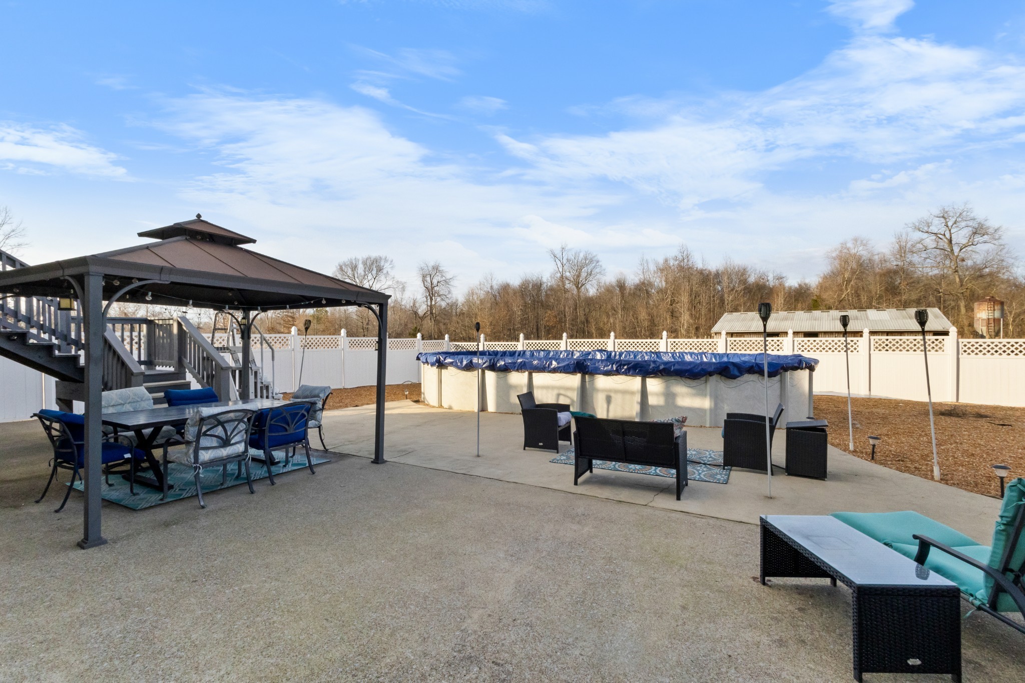 4591 Pineywoods Road Adams, TN 37010 - Photo 48 of 83 a view of a patio with couches and table and chairs under an umbrella