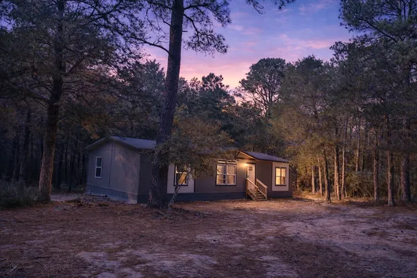 a view of a house with a tree in the background