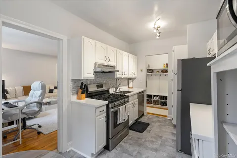 a kitchen with stainless steel appliances a stove a refrigerator a sink a stove a table and chairs