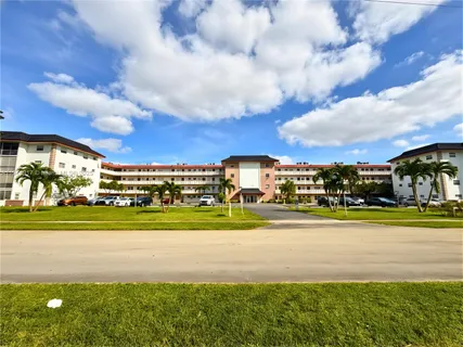 a view of a house in a big yard with large trees