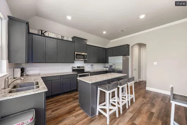 a kitchen with stainless steel appliances granite countertop a sink stove and refrigerator