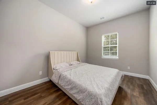 a bedroom with a bed and wooden floor