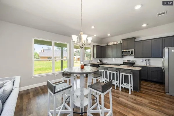 a kitchen with a dining table chairs and granite counter tops