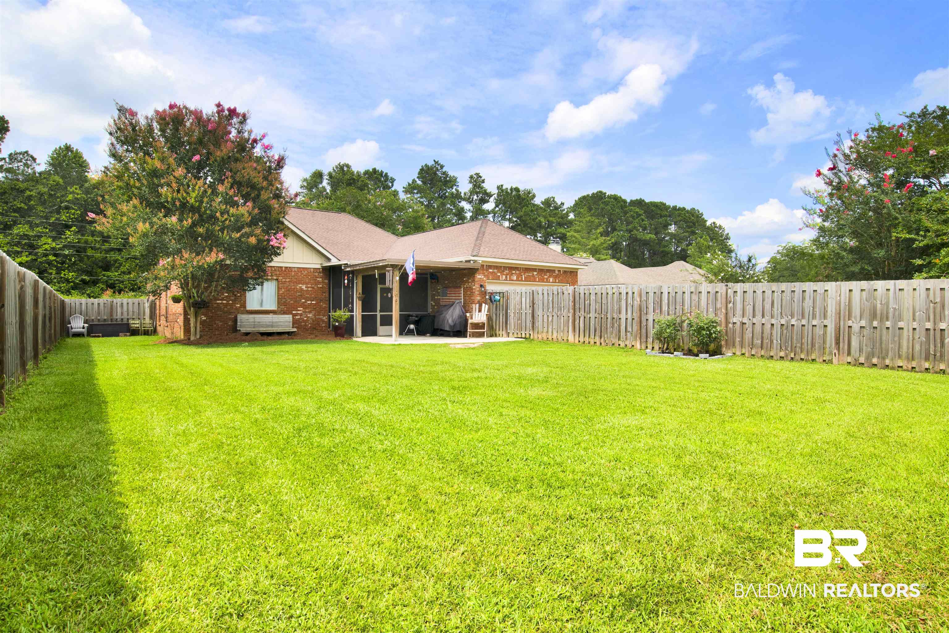 10368 Gayfer Rd Extension Fairhope, AL 36532 - Photo 36 of 43 Expansive backyard featuring a lush green lawn, full privacy fencing, and a covered back patio