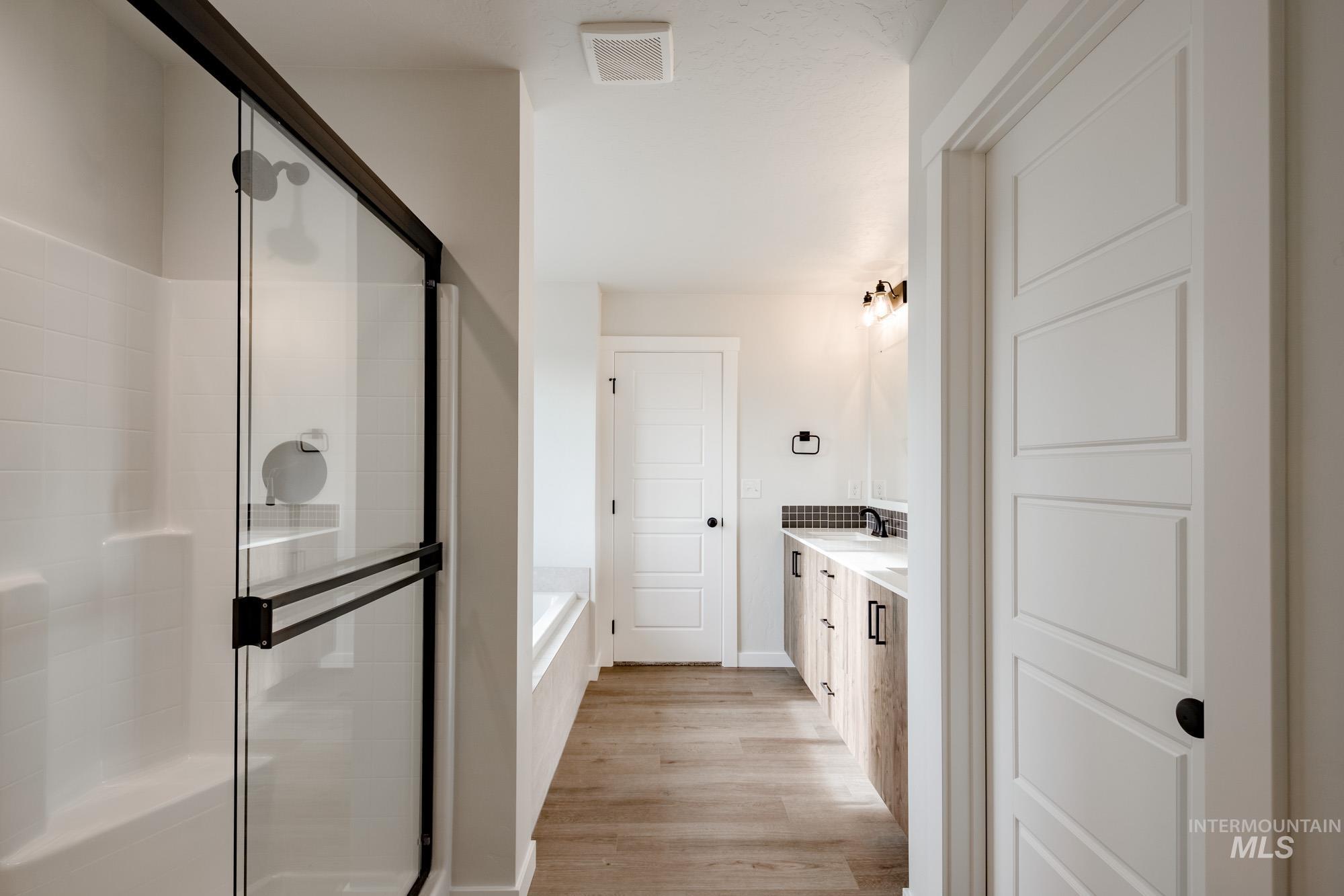 2135 South Border Way Meridian, ID 83642 - Photo 16 of 24 Bathroom featuring double vanity, a bath, a shower stall, and light wood-style flooring