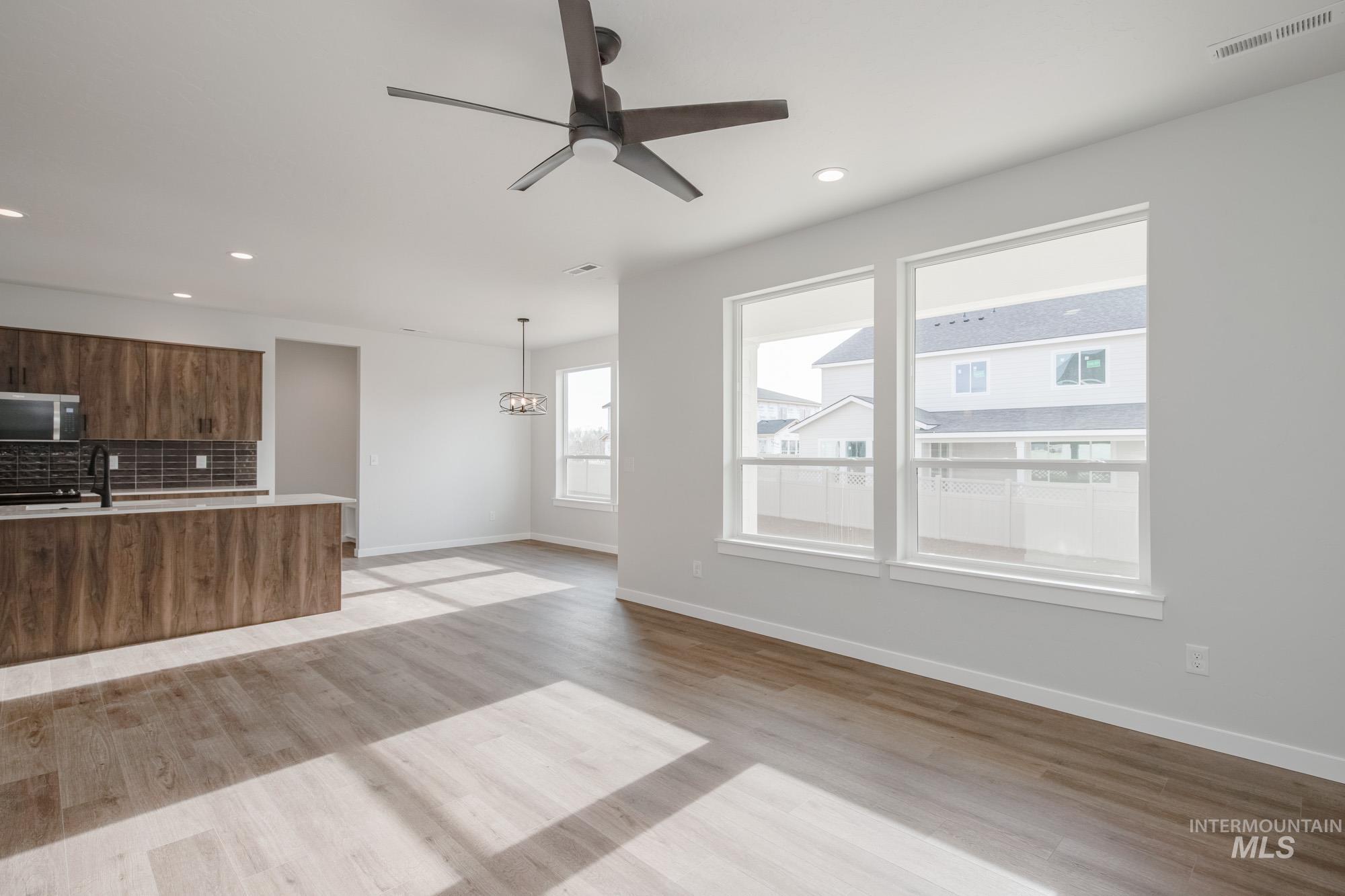 2135 South Border Way Meridian, ID 83642 - Photo 5 of 24 Unfurnished living room featuring ceiling fan, light wood-style floors, and recessed lighting