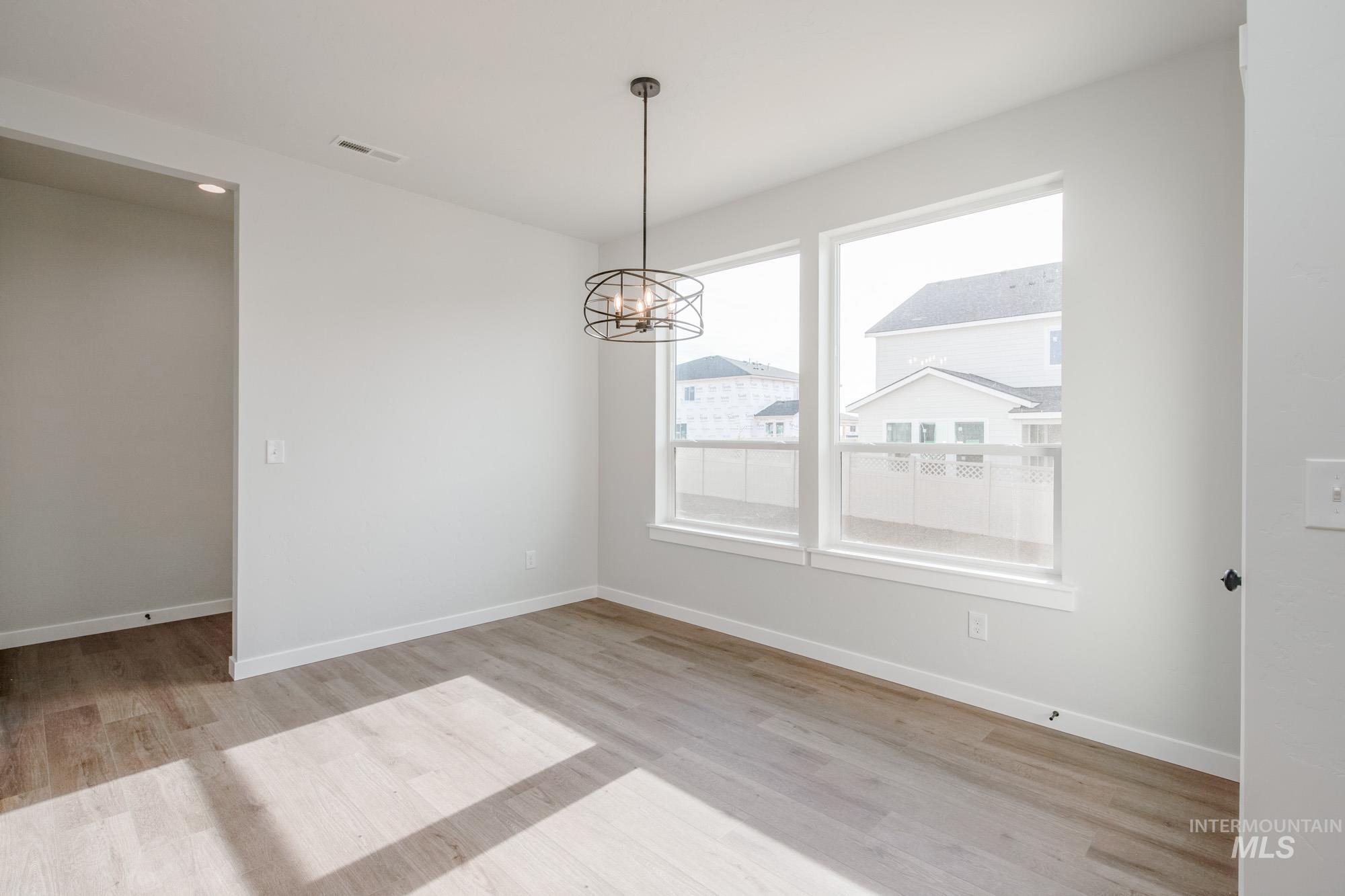 2135 South Border Way Meridian, ID 83642 - Photo 7 of 24 Unfurnished room with a chandelier and light wood-style flooring