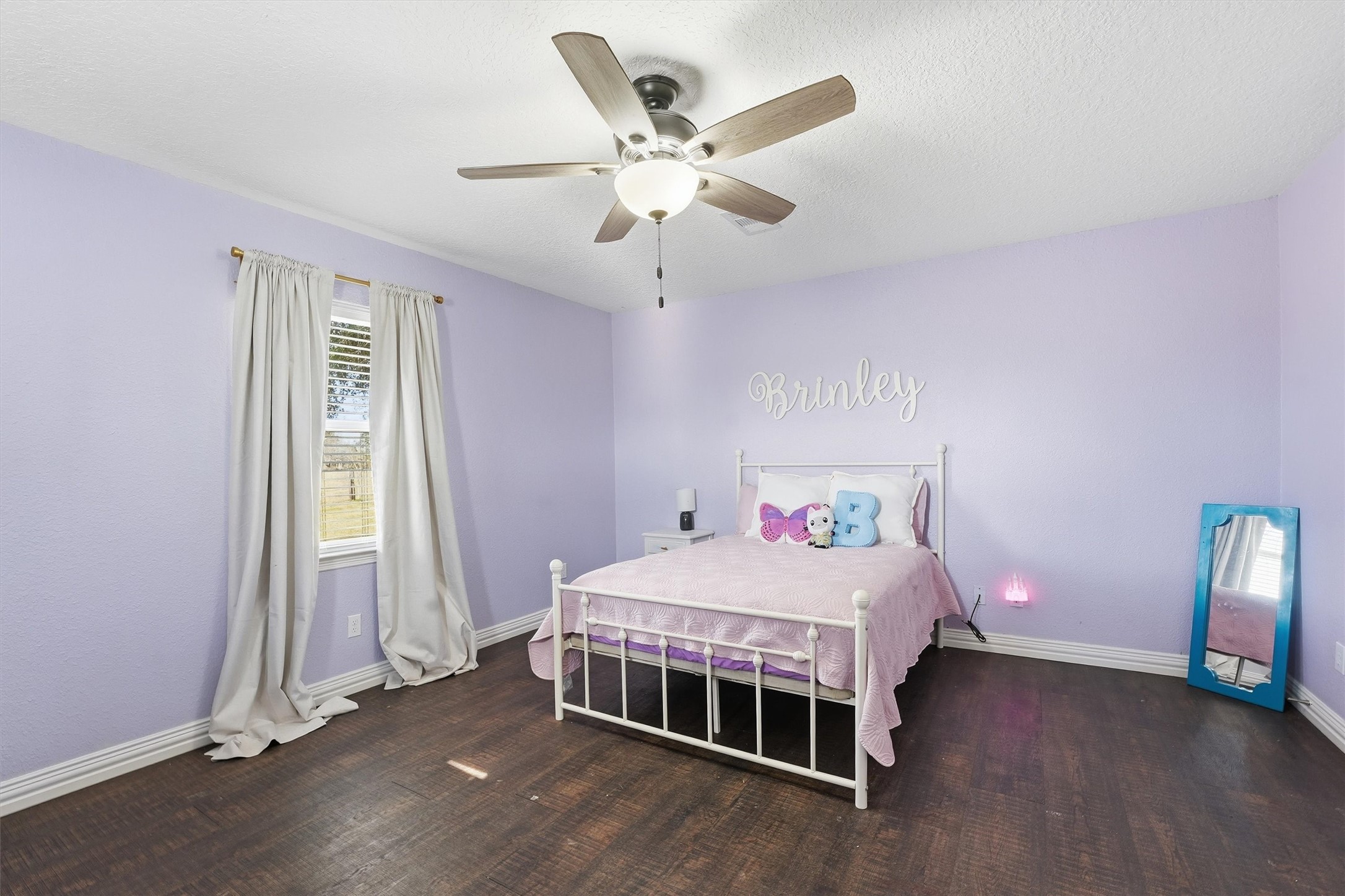 611 Reidland Road Crosby, TX 77532 - Photo 14 of 35 This bedroom includes dark wood flooring, ceiling fan and window for ample lighting