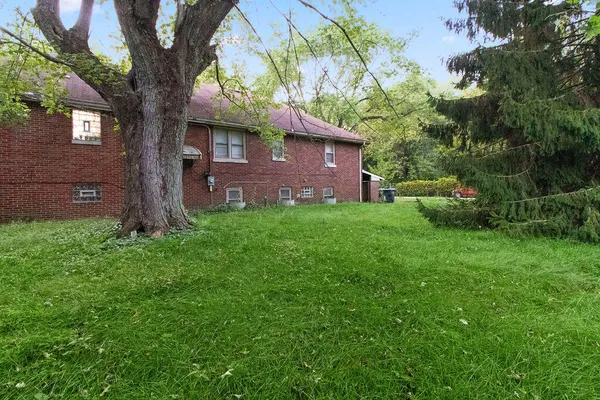 a view of a tree in front of a brick house
