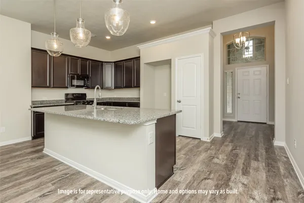 a kitchen with kitchen island a counter top space appliances and cabinets