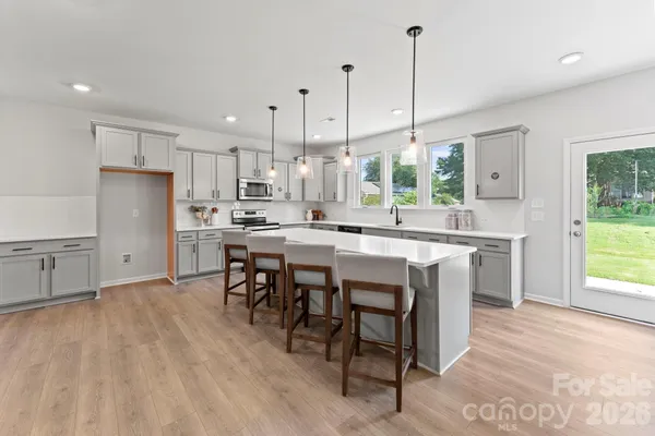 a kitchen with kitchen island a large counter space a sink appliances and cabinets