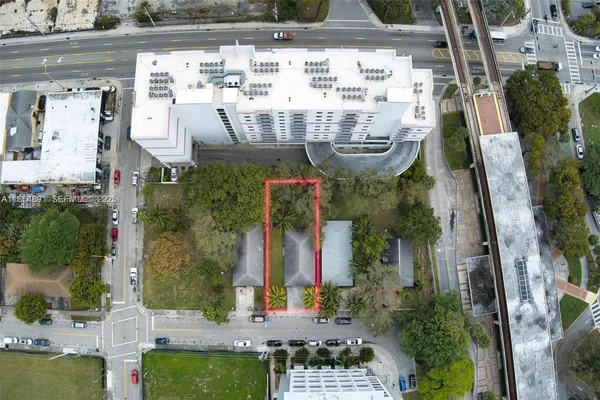 an aerial view of a house with swimming pool and large trees