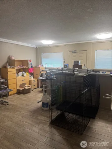 a view of a hallway with wooden floor and living room