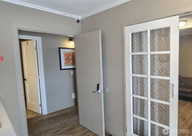 a view of a hallway with wooden floor and closet