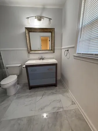a bathroom with a toilet sink and mirror
