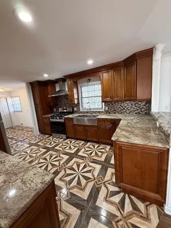 a kitchen with stainless steel appliances granite countertop a stove a sink a microwave a refrigerator and cabinets