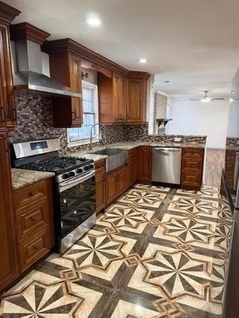 a kitchen with stainless steel appliances kitchen island granite countertop a sink and cabinets