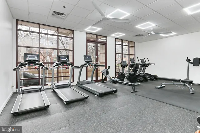a room with gym equipment and large windows