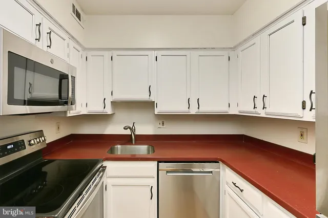 a kitchen with stainless steel appliances white cabinets and a sink