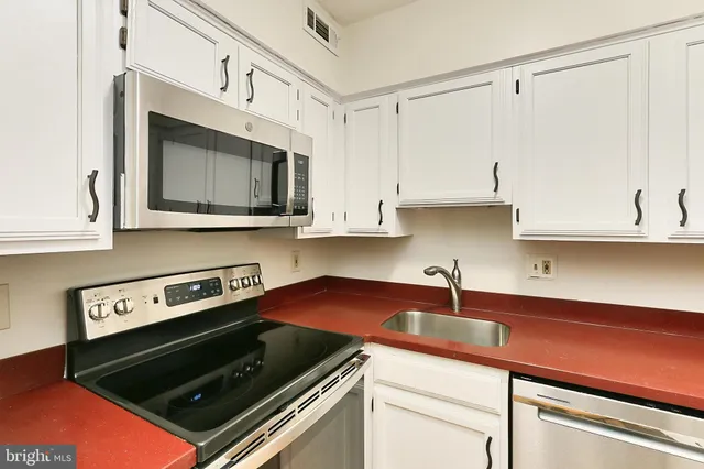 a kitchen with stainless steel appliances a stove a microwave and cabinets