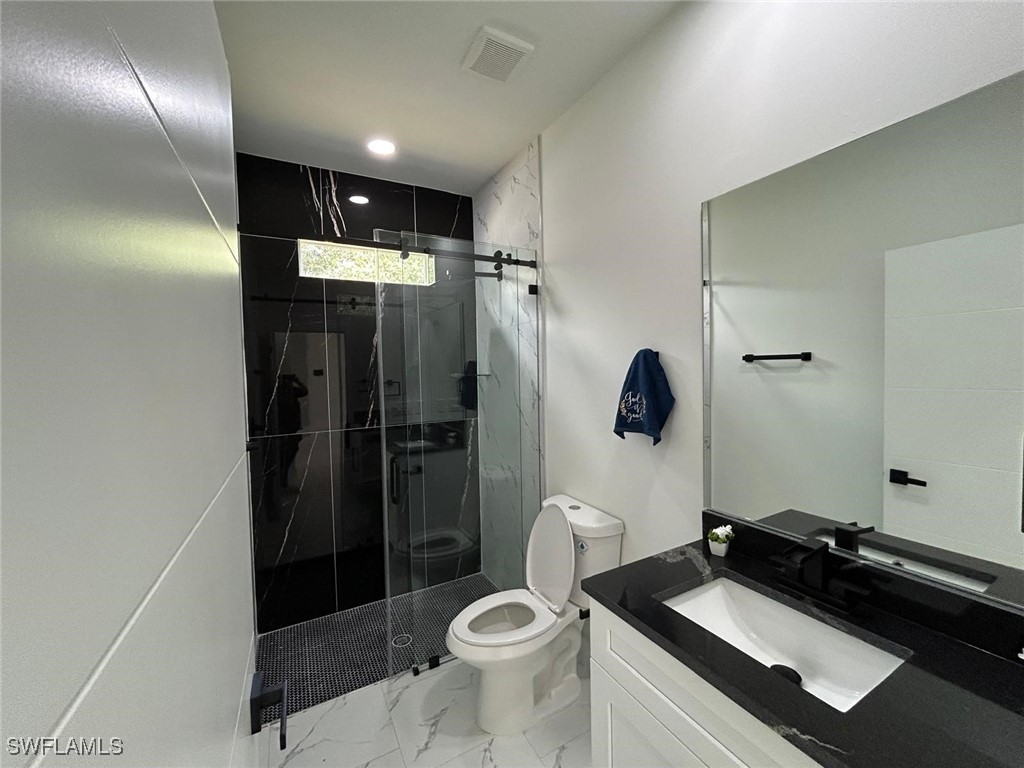 4204 East 24th Street Alva, FL 33920 - Photo 31 of 34 a bathroom with a sink a toilet a shower and mirror