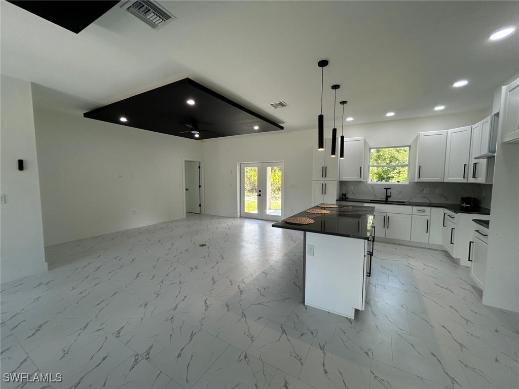 4204 East 24th Street Alva, FL 33920 - Photo 9 of 34 a large kitchen with stainless steel appliances a large counter top a stove a sink a refrigerator and a granite counter tops