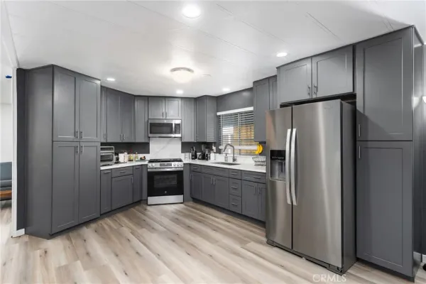a kitchen with stainless steel appliances granite countertop a refrigerator and a stove top oven