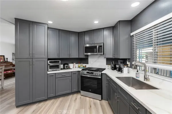 a kitchen with a sink stove top oven and cabinets