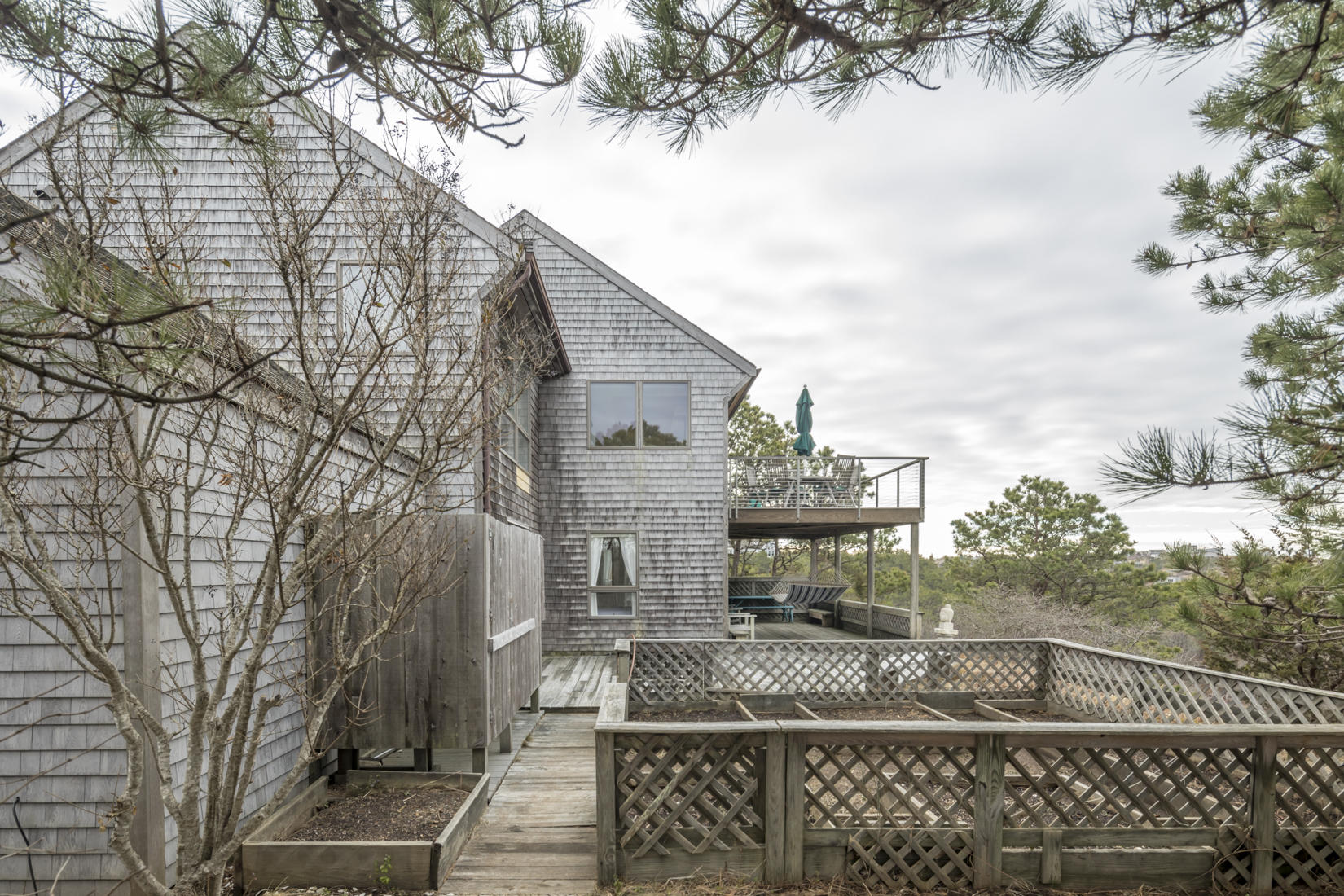 3 High Ridge Road Truro, MA 02666 - Photo 28 of 43 a view of a brick house next to a yard with large trees