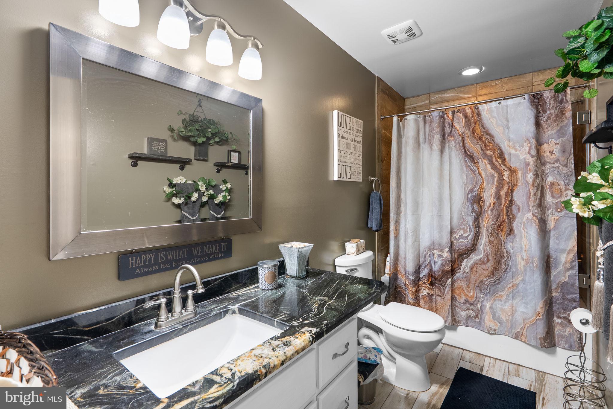 13100 Croom Road Upper Marlboro, MD 20772 - Photo 21 of 37 a bathroom with a granite countertop sink vanity mirror and toilet